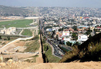 A photo of the U.S. / Mexico border, showing farmland